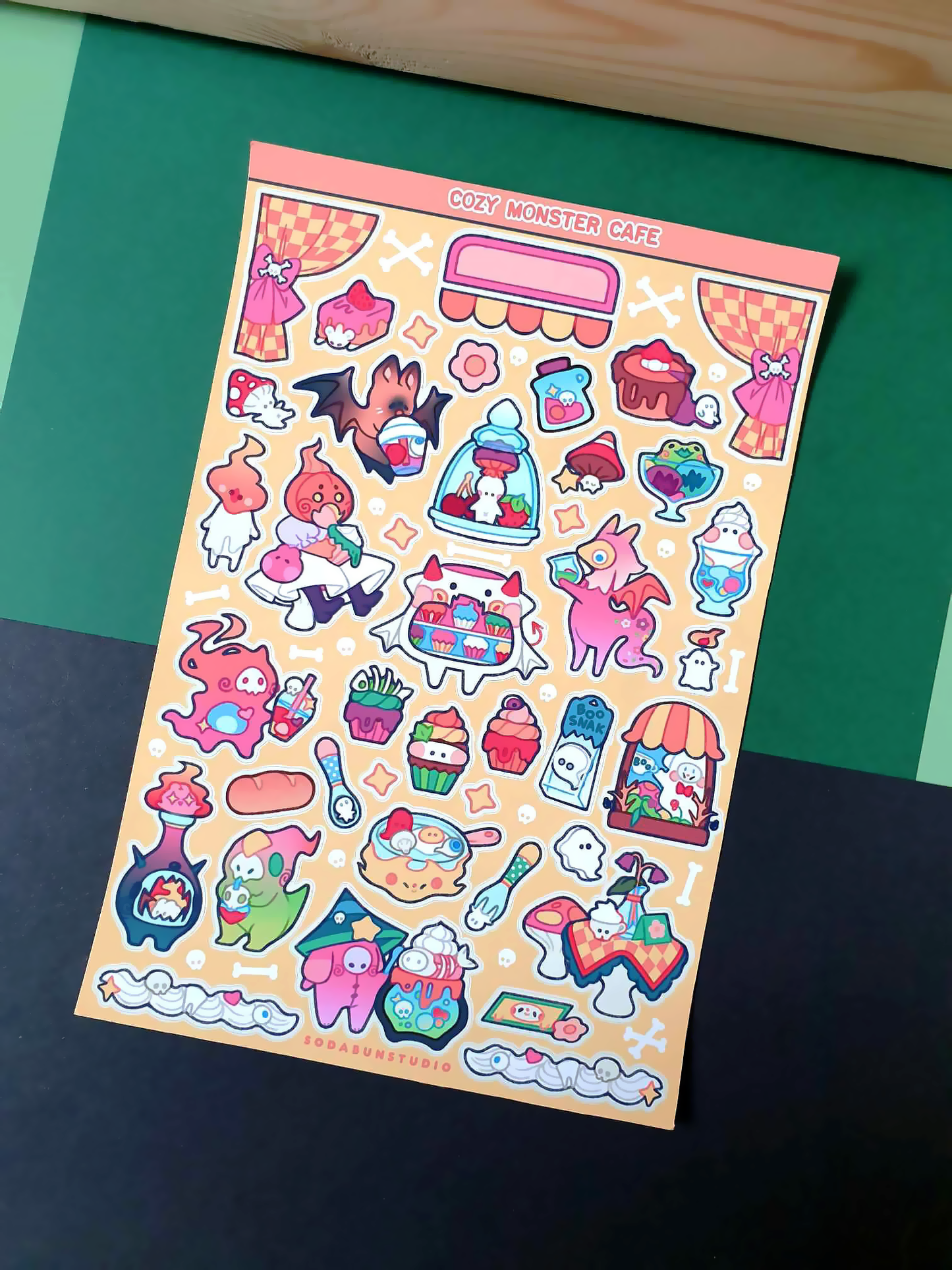 Coy Apricot Cozy Monster Cafe Sticker Sheet featuring cute monsters with cafe treats like coffee, pastries, and more, in bright vibrant colours for journaling and scrapbooking. Front view.