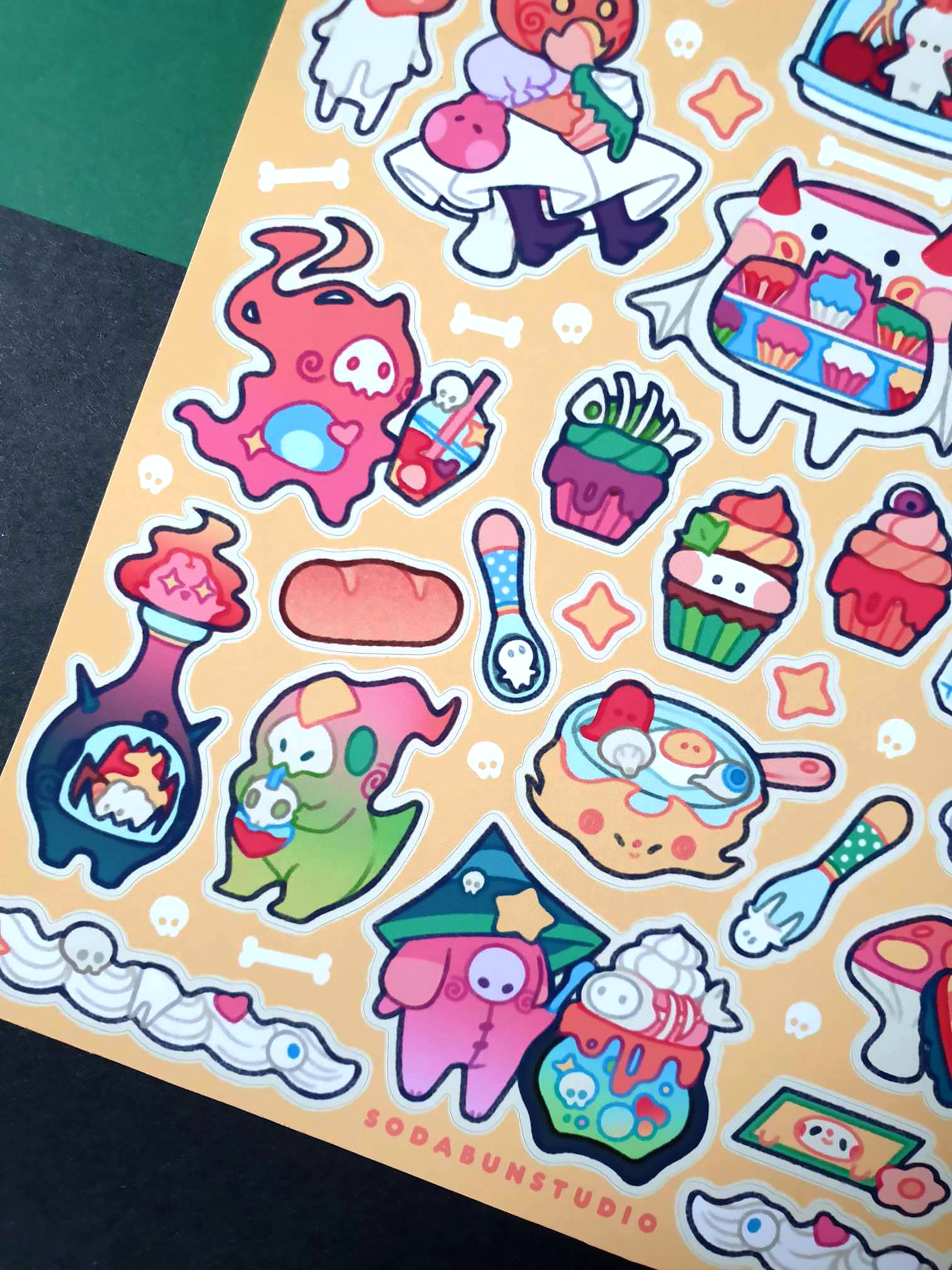 Coy Apricot Cozy Monster Cafe Sticker Sheet featuring cute monsters with cafe treats like coffee, pastries, and more, in bright vibrant colours for journaling and scrapbooking. Corner view.