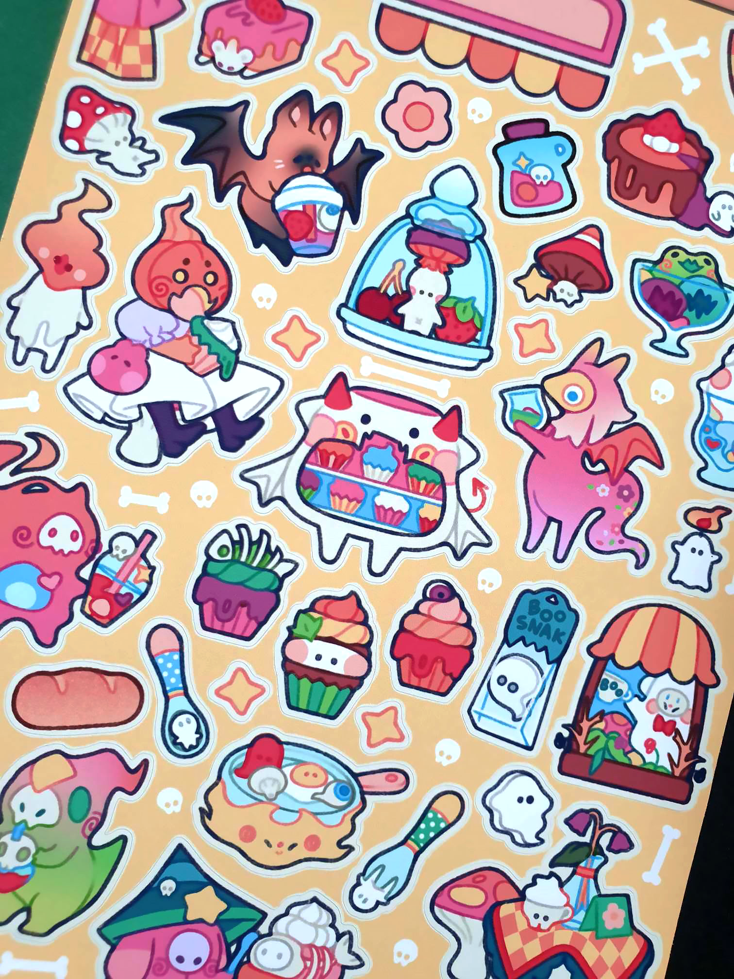 Coy Apricot Cozy Monster Cafe Sticker Sheet featuring cute monsters with cafe treats like coffee, pastries, and more, in bright vibrant colours for journaling and scrapbooking. Close Up.